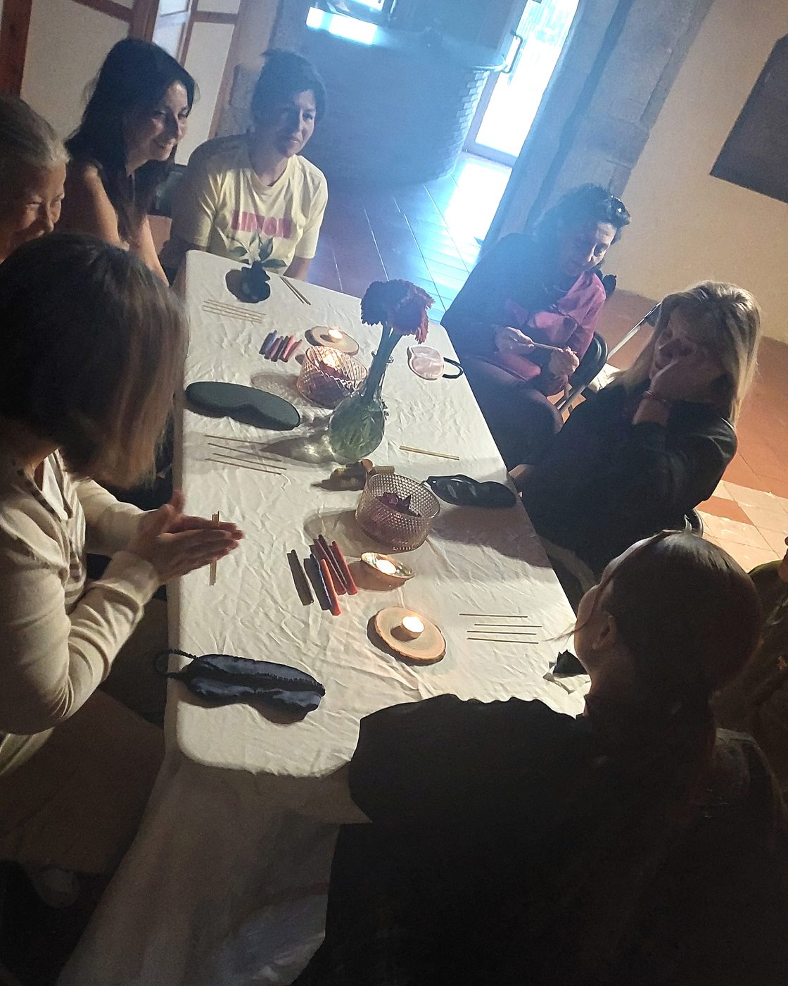 Ritual con objetos y cartas de Tarot dispuestos sobre una mesa durante un círculo.